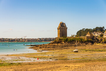 The Solidor Tower in Saint-Malo in Brittany, under a blue sky and at low tide. - obrazy, fototapety, plakaty