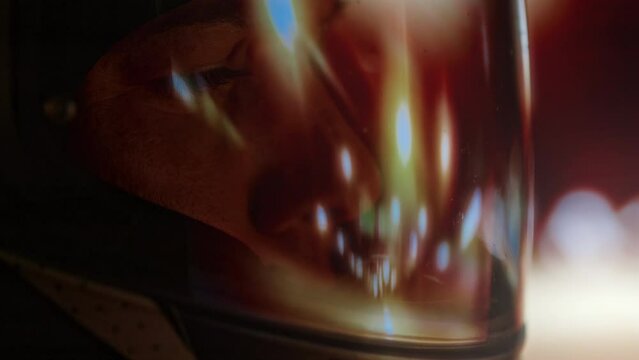 Side extreme close-up of profile of female professional racer looking worried while driving sports car on racetrack during championship at night
