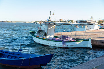 Obraz premium small fishing boats moored on the waterfront in the city Sant'Antioco, Sardinia, Italy