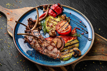 Grilled lamb ribs with vegetables. Menu for a pub on a dark background. Colorful juicy food photography.