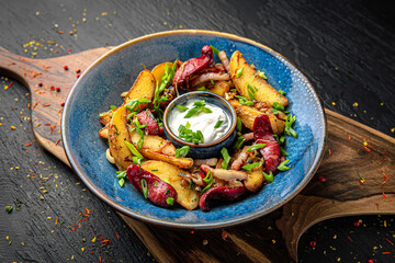 Home fried potatoes with smoked hunting sausages. Menu for a pub on a dark background. Colorful juicy food photography.