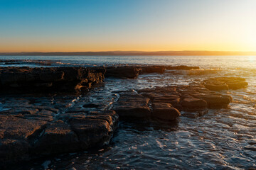beautiful sun rise over the rocky coast in winter