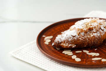 Almond Croissant on clay plate close up