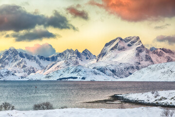Stunning morning view of Torsfjorden fjord  and snowy mountain peaks at background during sunrise.