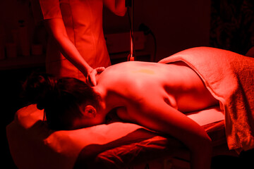 Chiropractic giving heat massage to a woman in the clinic