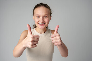 Young Girl Giving Thumbs Up Sign in studio