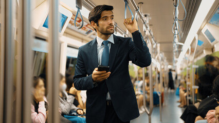 Professional smart business man looking phone while standing at train surrounded by people....