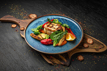 Sturgeon steak with roasted vegetables. Menu for a pub on a dark background. Colorful juicy food...