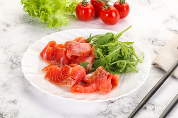 Sliced salmon with fresh arugula