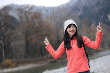 Alone in nature's embrace, Asian woman in a pink fleece. Climbing, standing by the lake, and exploring the scenic beauty of Japan's breathtaking destination. - 792478449