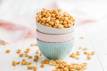 Salted roasted peanuts in bowl on kitchen table - 792479287