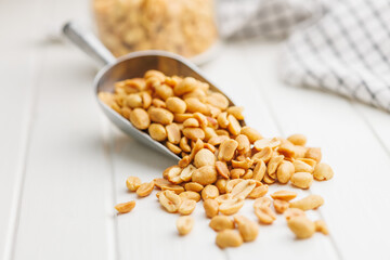Salted roasted peanuts in scoop on kitchen table - 792479614