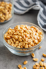 Salted roasted peanuts in bowl on kitchen table - 792479655