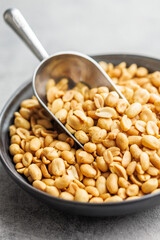 Salted roasted peanuts on plate  on kitchen table