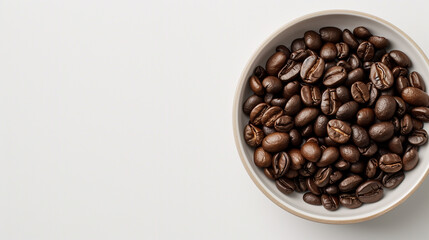 Fototapeta premium Coffee beans in a white bowl on a white table, space on the left, top view
