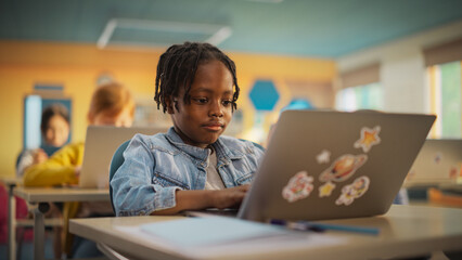 Talented Small African American Boy Using a Laptop Computer in Class. Portrait of a Happy Elementary School Student Studying Hard, Learning New Things, Getting Modern Education Online