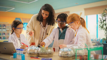 Team of Kids Finishing a Science Project. Talented Boys and Girls Growing Experimental Plants in a...