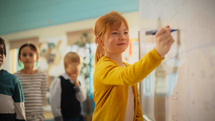 Portrait of a Cute Girl with Bright Ginger Hair Finding a Solution to a Mathematical Task on a...