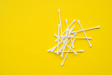 Cotton buds on a yellow background close-up