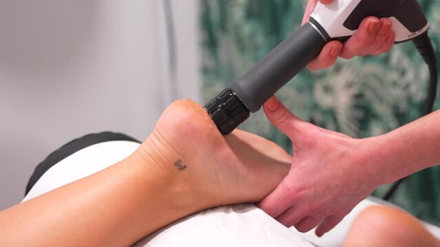 Vertical photo of shock waves therapy to release the pain on patient