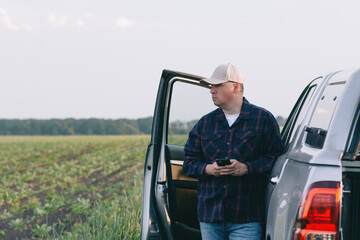 A man stands next to a truck parked in a field, creating a juxtaposition between human and...