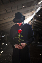 Man in the classic coat with a red rose flower portrait.