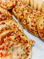 Freshly baked mini pizzas with melted cheese and red bell peppers on top