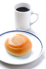 ふっくらと丸く、ゴマがかかった、あんぱんとコーヒー
