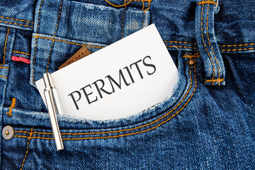 A word PERMITS on a business card peeking out of a jeans pocket - obrazy, fototapety, plakaty