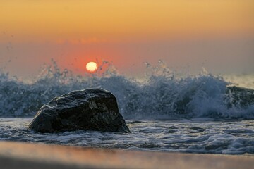 Peaceful seashore with waves crashing rock evening