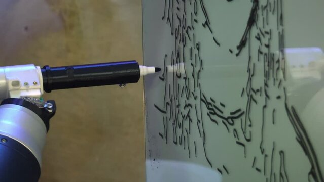 Futuristic robot arm with marker drawing portrait of woman on whiteboard in exhibition