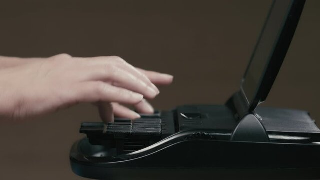 Court reporter hands profile closeup typing on stenographer machine 