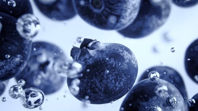 Super Slow Motion Shot of Fresh Blueberries Falling into Water and Creating Bubbles at 1000fps.