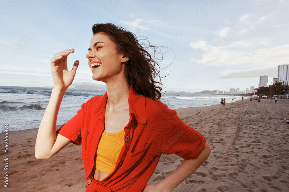 Wall mural Joyful Woman Dancing in Red Clothes on a Sunny Beach