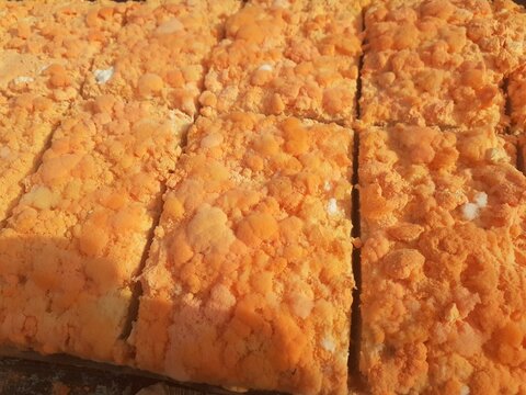 Raw oncom on a wooden shelf at a traditional roadside market trader.Oncom is mushroom-infused tempeh made from peanut cake and tofu dregs.Oncom is a fermented food with several types of mold.