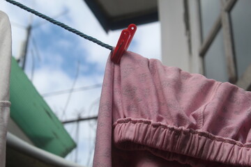 Clothes drying on the clothesline. Clean clothes hanging on washing line against sky. Drying laundry