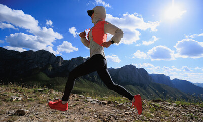 Woman ultramarathon runne running at mountain top