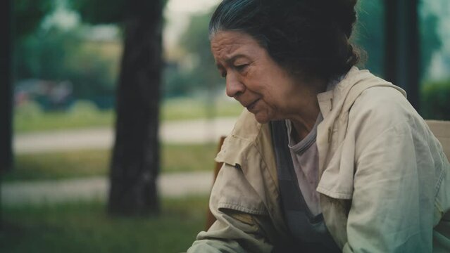 Unhappy homeless senior woman crying, sitting alone in street, poverty issue