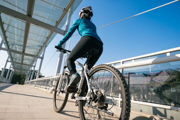 Woman riding bike at city on sunny day