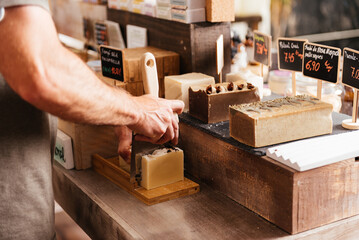Artisanal Soap Being Hand-Cut for Customers at a Local Grocery Market