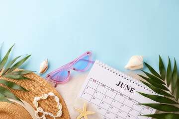 Summer holiday calendar, flat lay of June planning with beach accessories on a blue background