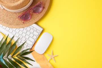 Top-view image combining work and leisure with a keyboard and beach accessories on a sunny yellow...