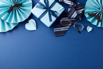 Stylish arrangement of Father's Day gifts, paper decorations, and accessories on blue background