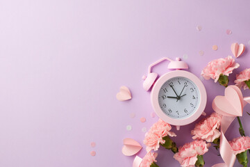 Pink alarm clock surrounded by festive confetti, hearts, and fresh flowers on a soft purple...