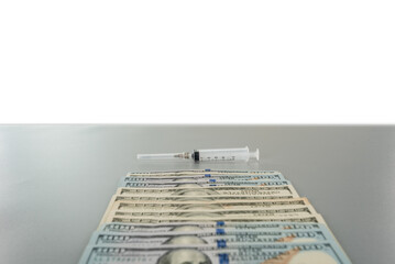 lying dollars syringe on gray table with copy space background