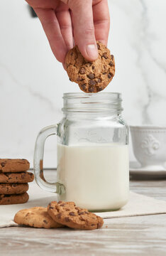 Dunking a chocolate chip cookie in milk