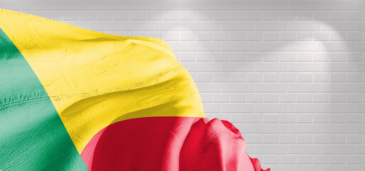 Benin national flag cloth fabric waving on beautiful bricks Background.	
