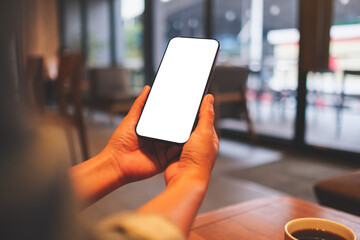 Mockup image of a woman holding mobile phone with blank desktop screen in cafe - 792602044
