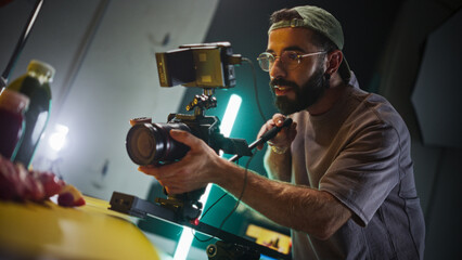 Focused Male Cinematographer With Beard And Glasses Operates Professional Camera On Film Set,...