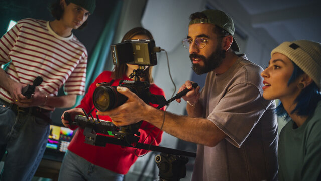 Dynamic Young Team Engaged In Video Production On A Film Set, Featuring Diverse Cinematographers With Camera Equipment, Focused On Creating Compelling Visual Content In A Studio Environment.